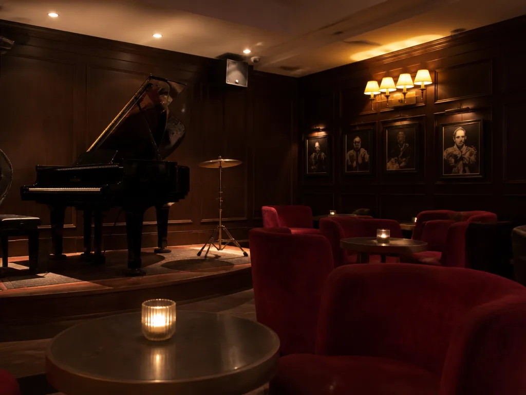 Dim jazz lounge interior with grand piano and amber lighting