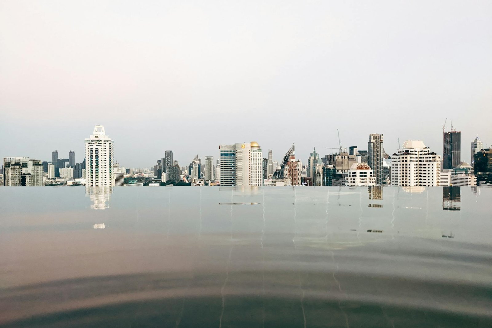 バンコクのラグジュアリーホテルにある川向きインフィニティプールと夕暮れ