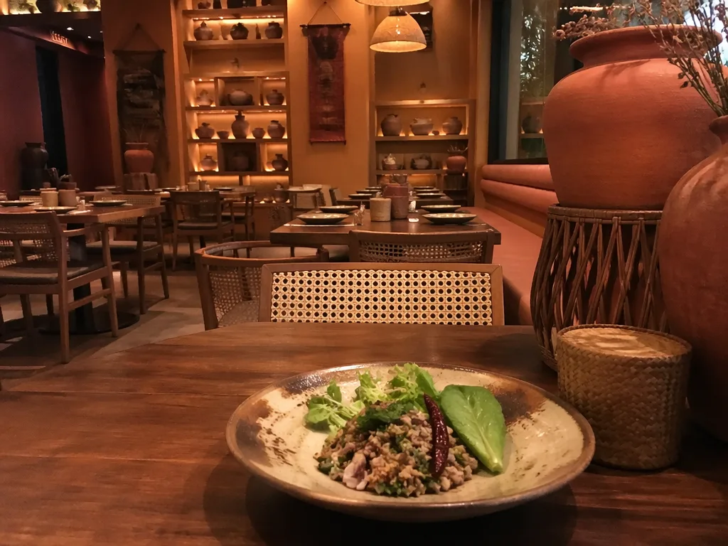 Bangkok Michelin fine dining tasting menu course on dark ceramic