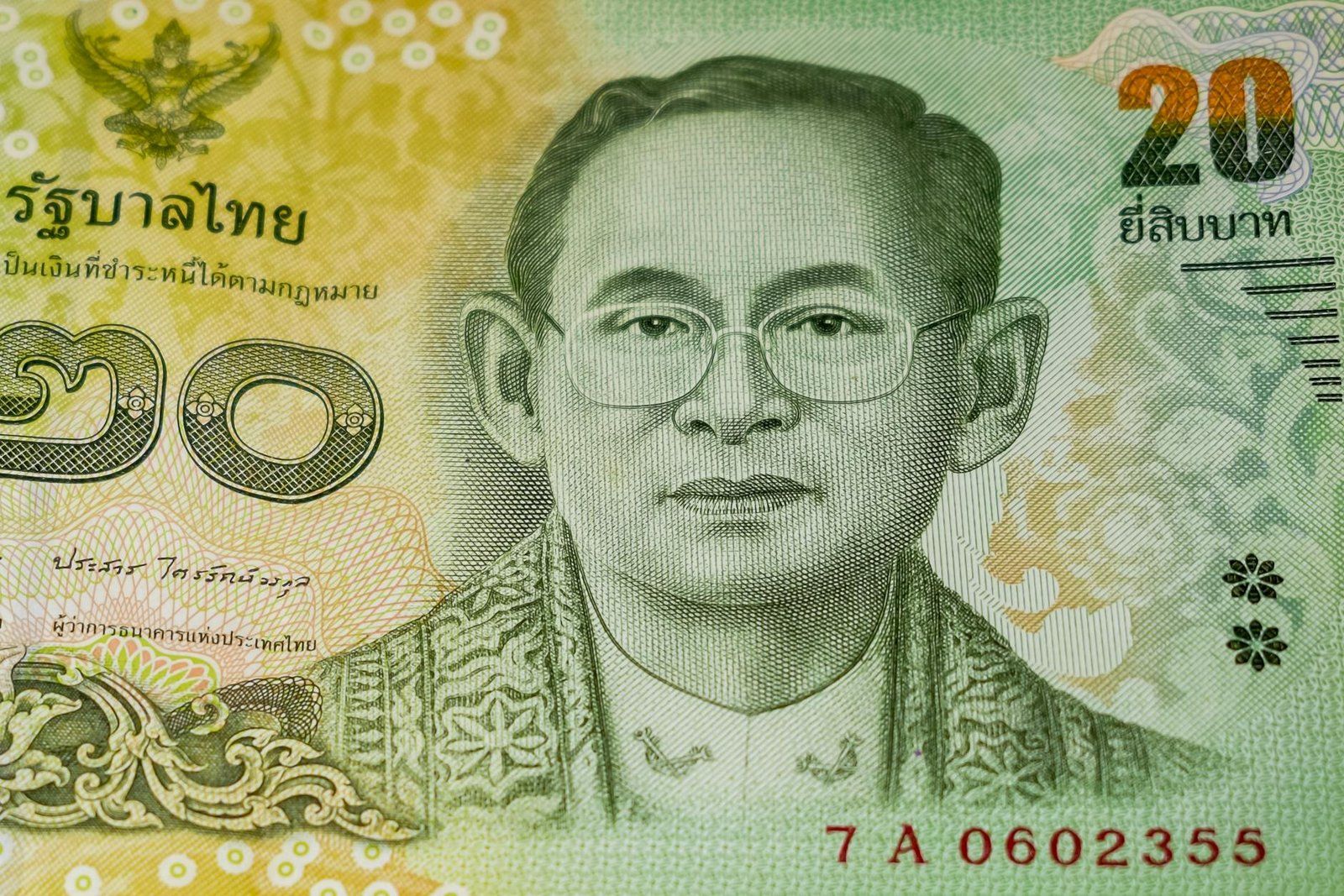 Thai baht cash bills and coins on wooden table