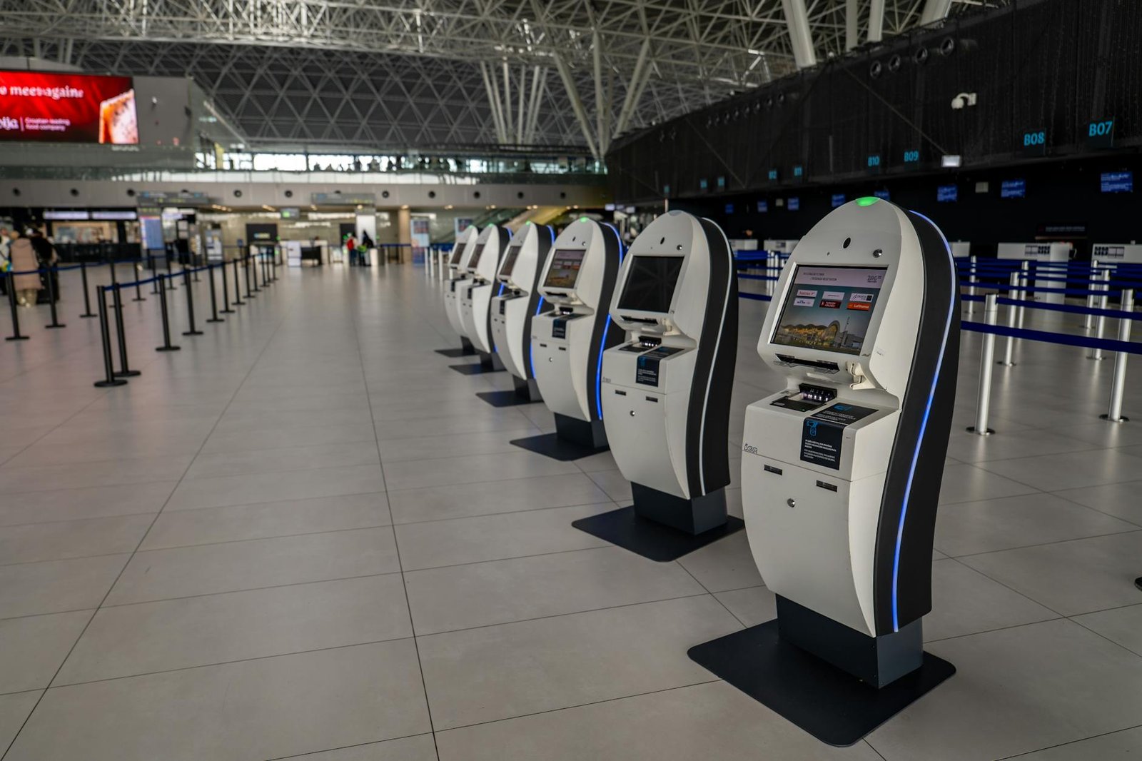 Traveler setting up phone at a Bangkok airport SIM counter with staff assisting