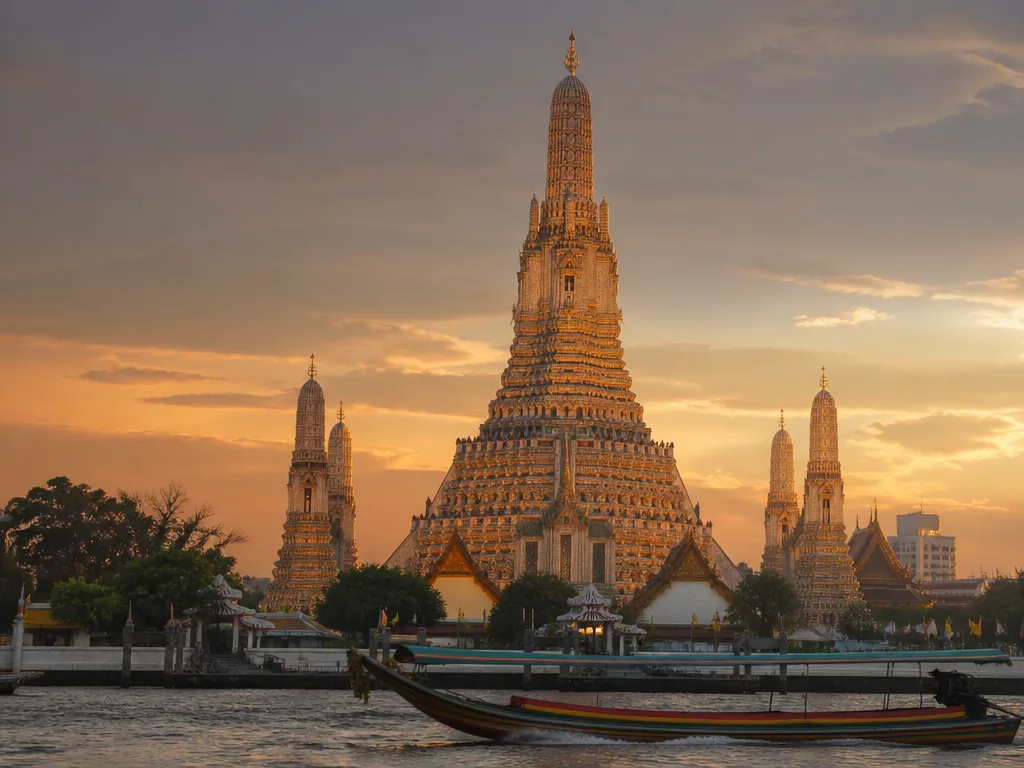 Wat Arun central prang towering over Chao Phraya river at golden hour