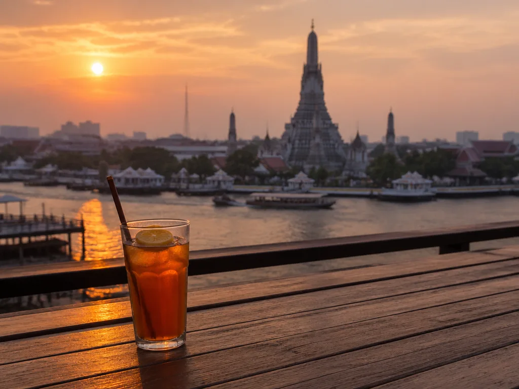 Wat Arun illuminated at dusk with reflection on river water