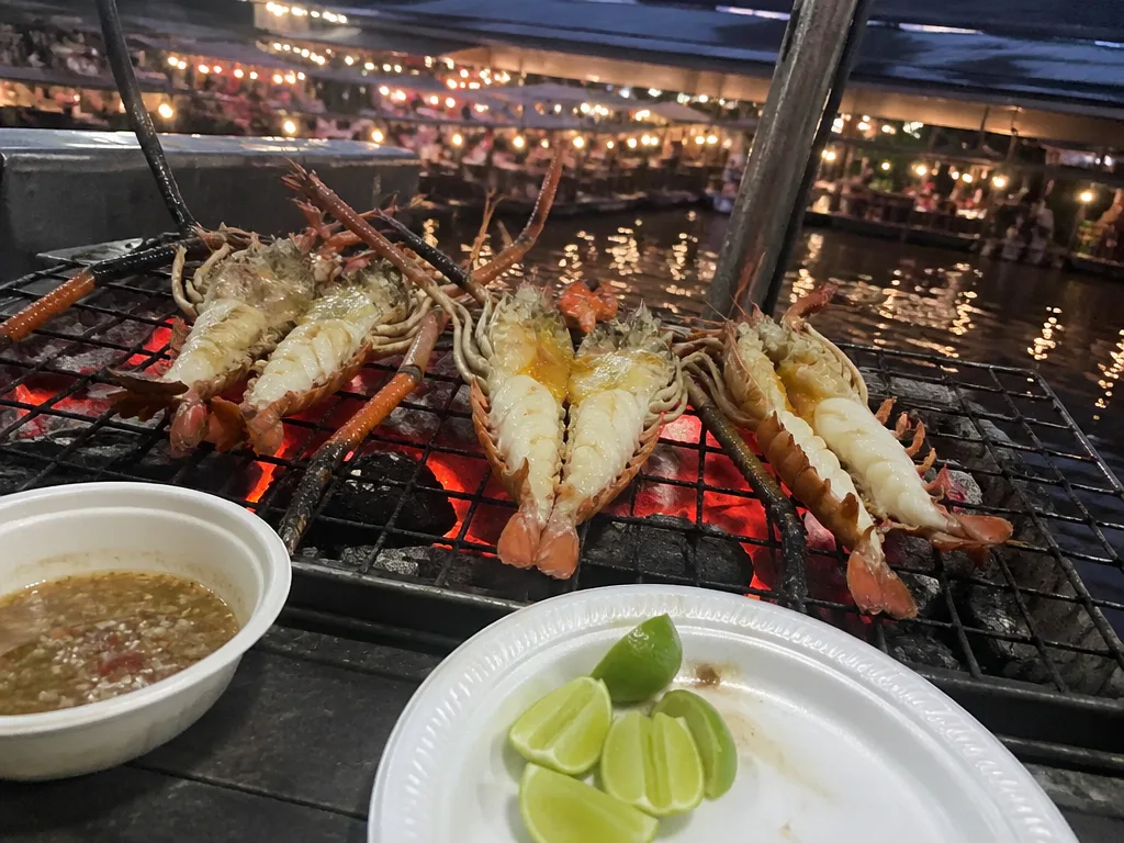 Grilled river prawns on a charcoal grill at evening market
