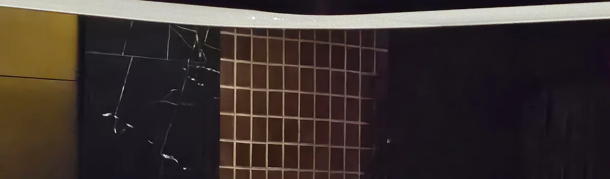 Black marble and brass grid tile wall at House of Savoy