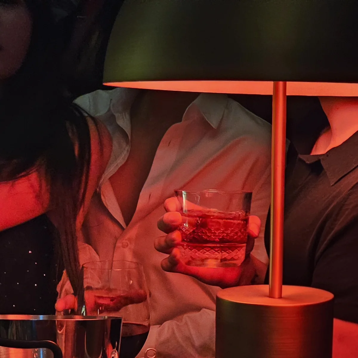 Red-lit lounge table with crystal whisky glass at House of Savoy