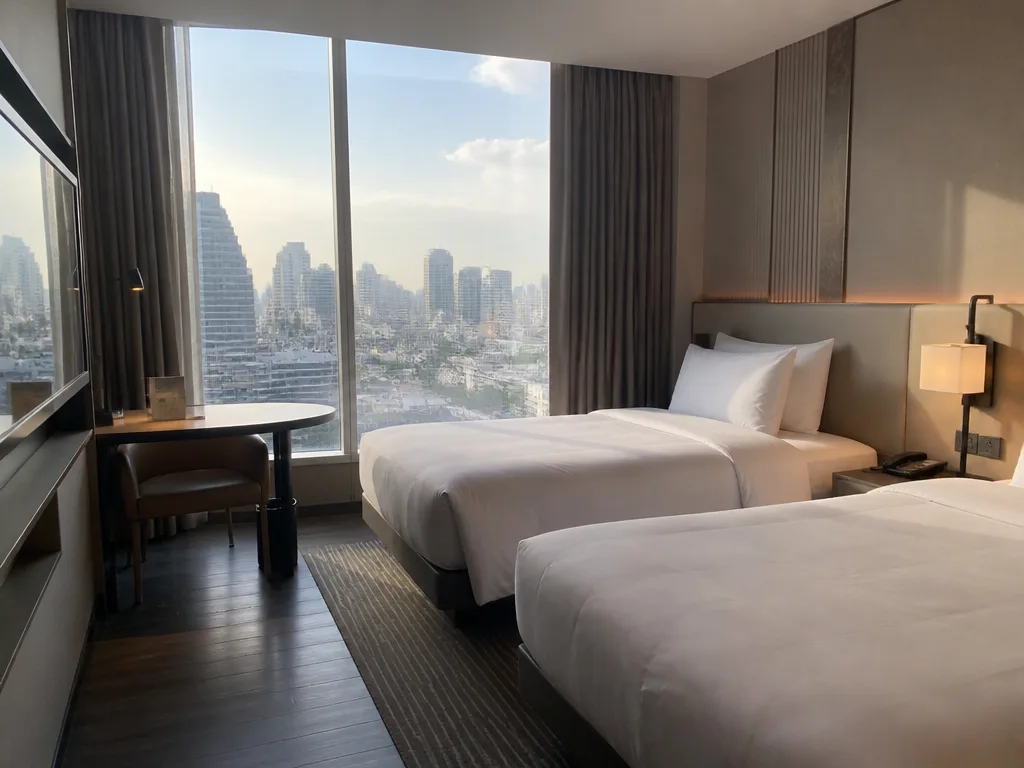 Modern Bangkok hotel room interior with two single beds and city view