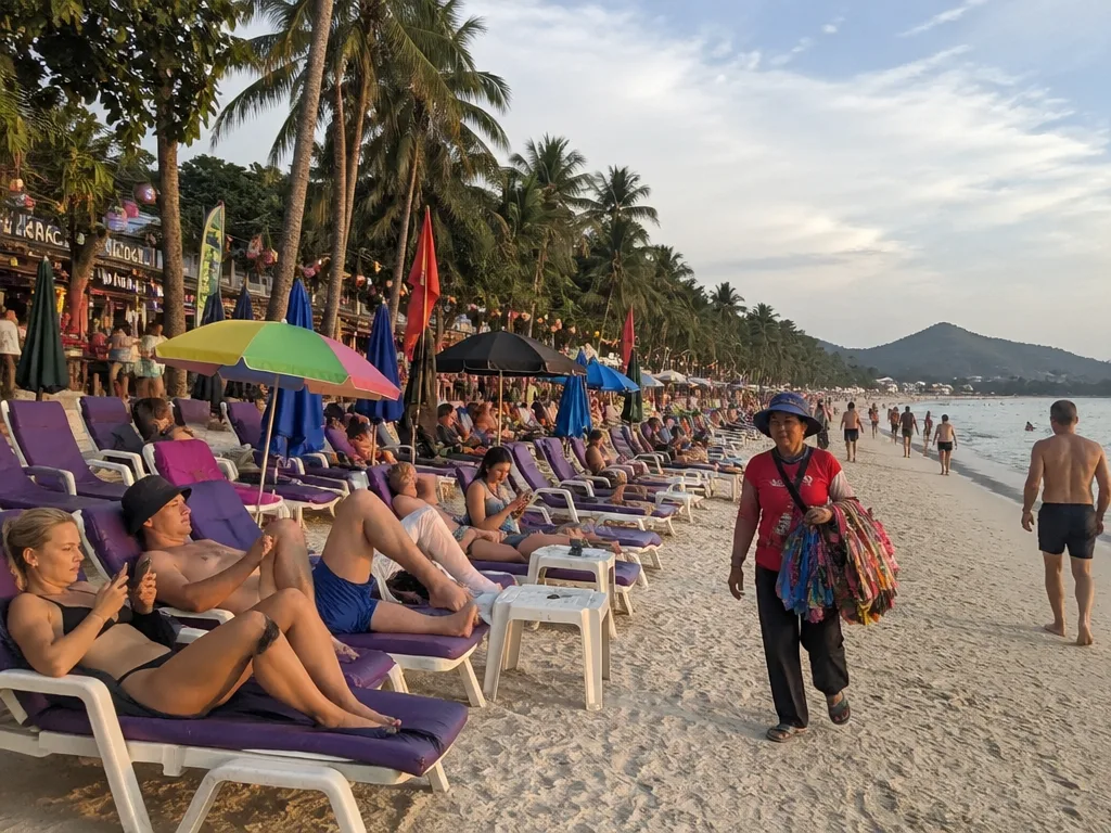 Busy Chaweng beach scene with sun loungers and bars