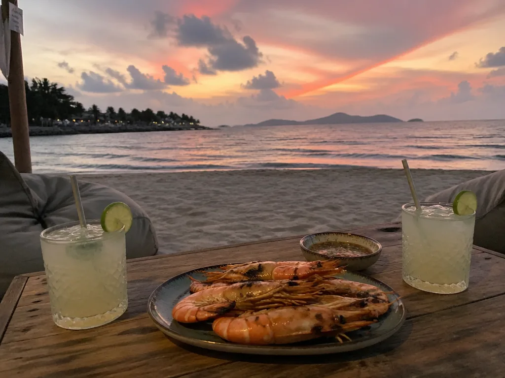 Beachfront sunset table with cocktails and Thai small plates at Fisherman's Village