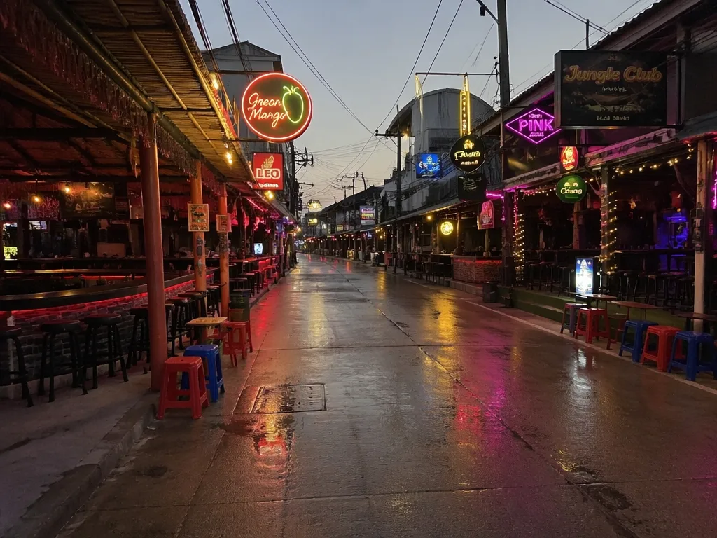 Empty Chaweng Beach Road bar strip at dusk with neon signs lining both sides