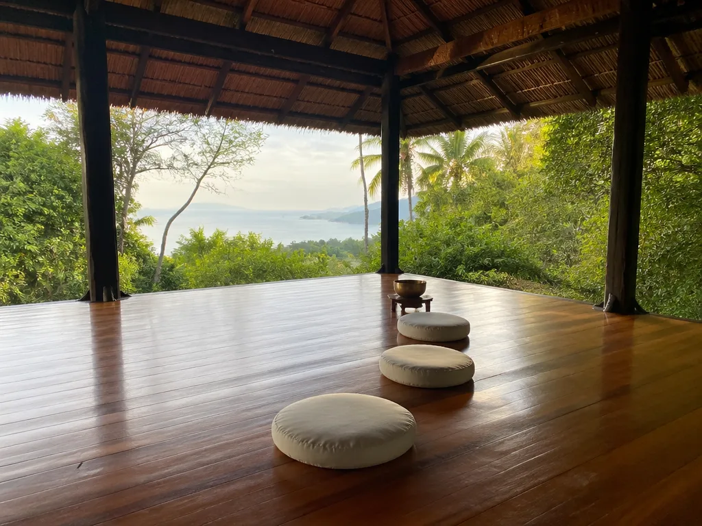 Open-air meditation pavilion at jungle wellness retreat with floor cushions