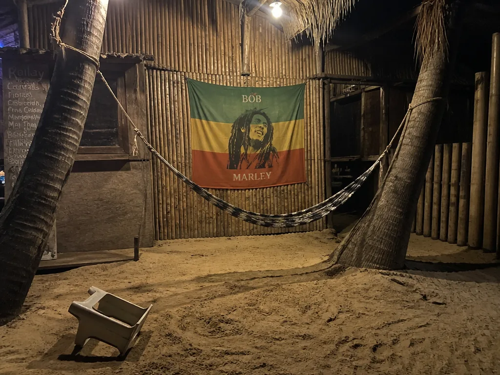 Empty hammock strung between two palms at a Railay reggae bar in low light