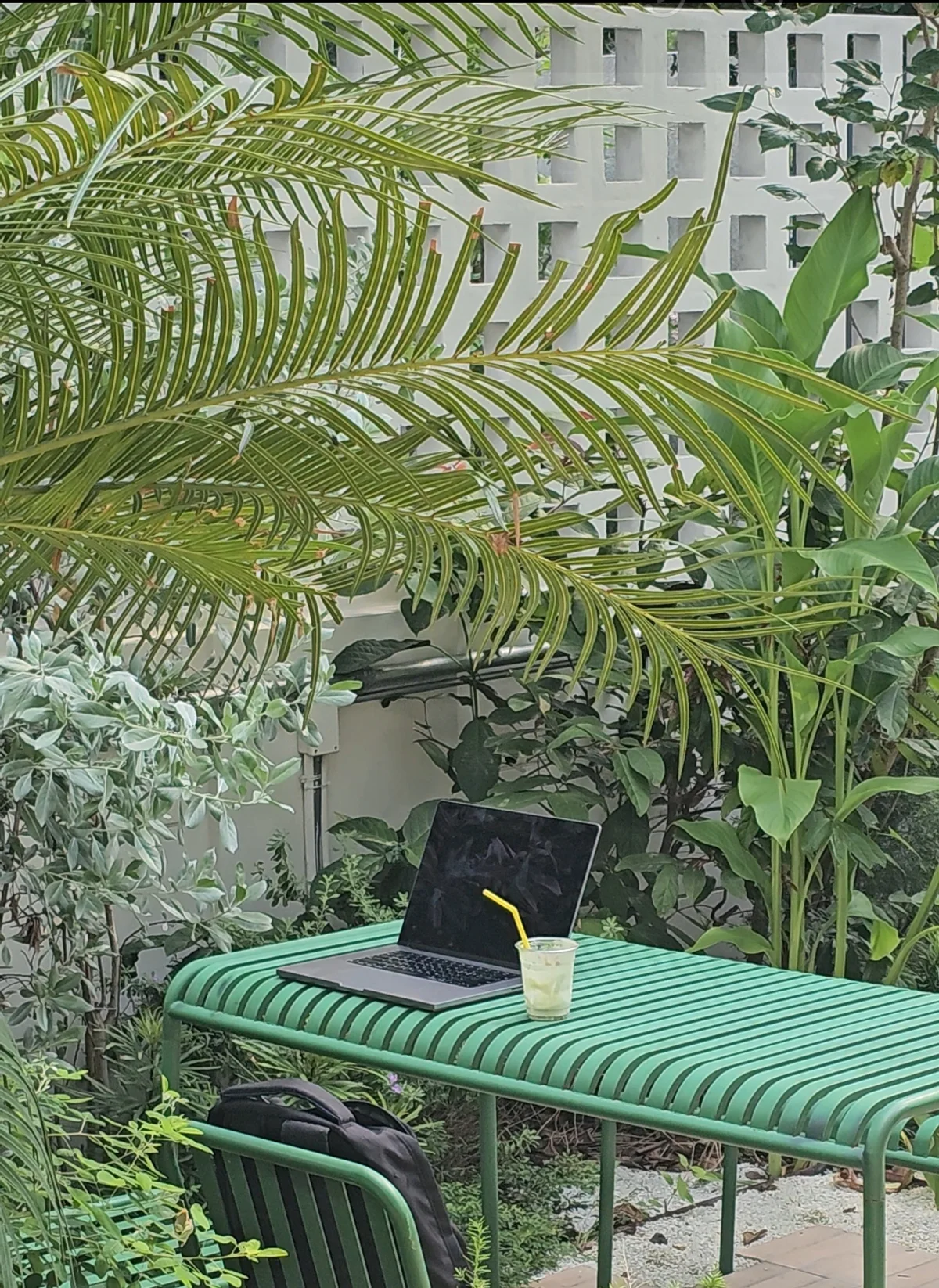 Garden seating with a laptop and a matcha drink at Matcha Edition