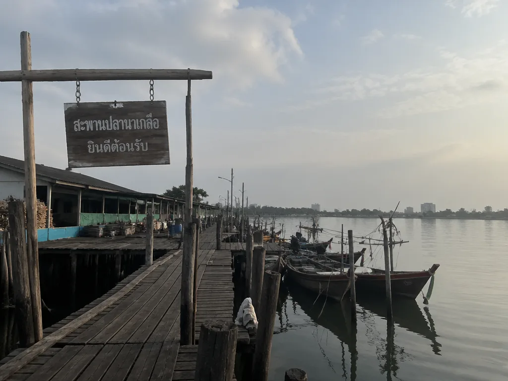 Quiet Naklua fishing pier morning with longtail boats