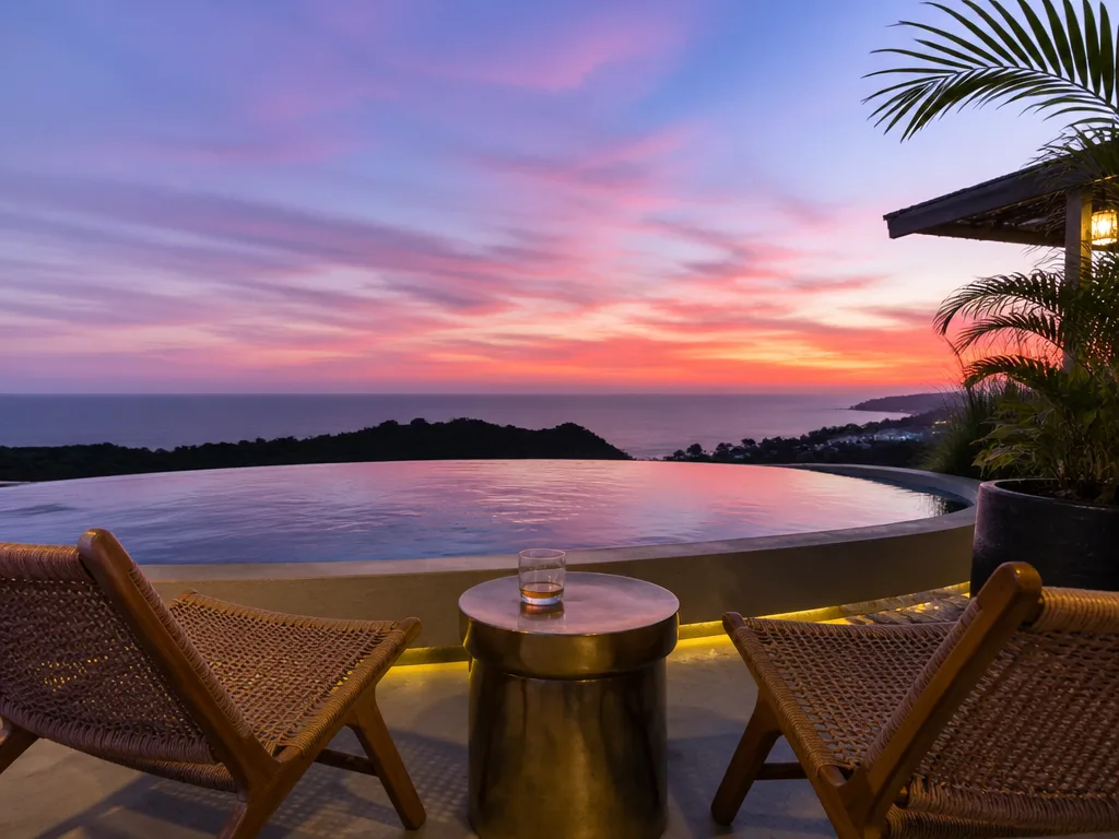 Rooftop bar infinity pool overlooking Andaman Sea at sunset