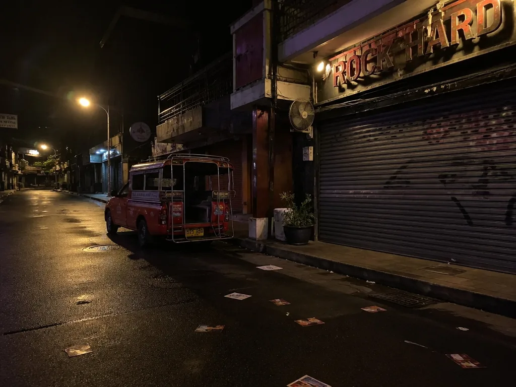 Empty Patong side street at 2am with songthaew truck and faded neon