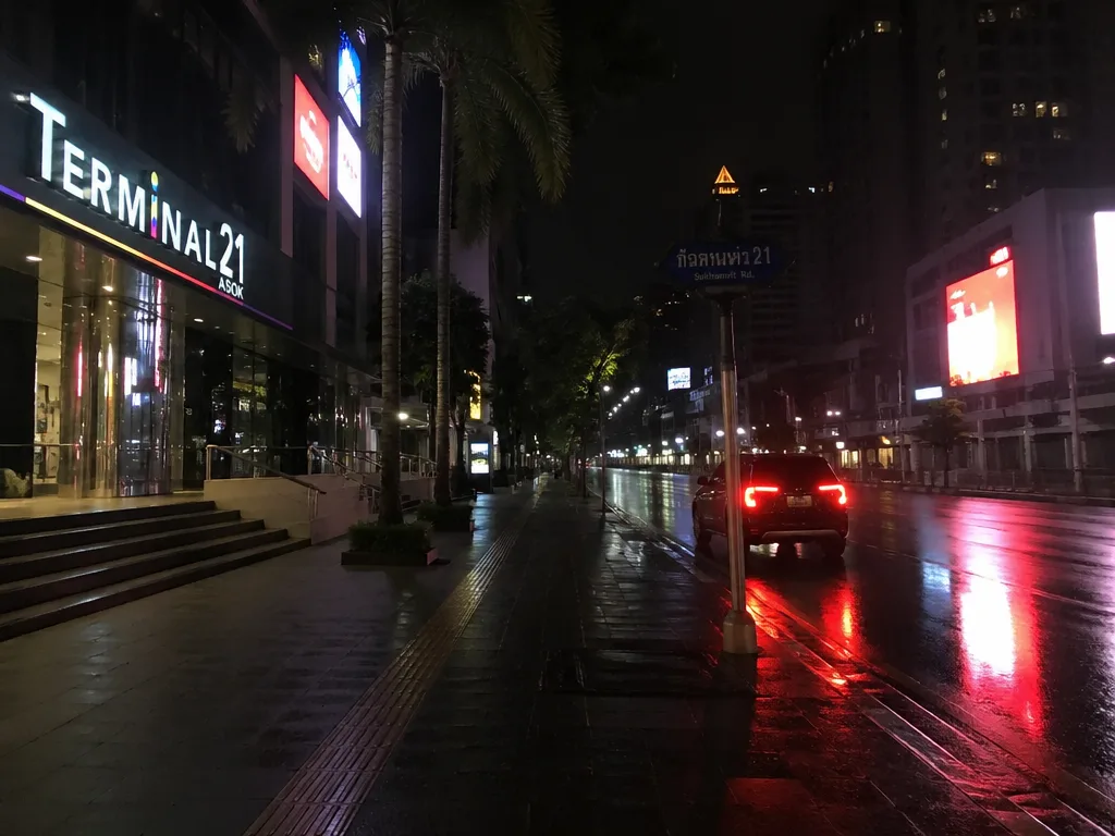 深夜スクンビット歩道とグラブ車赤いテールランプ