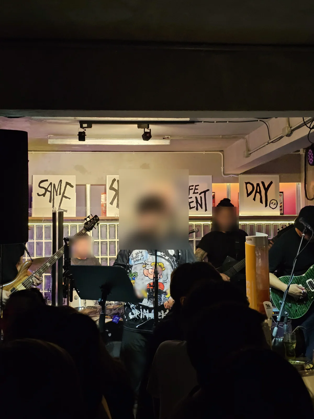 SSDD live band playing in front of hand-painted signs