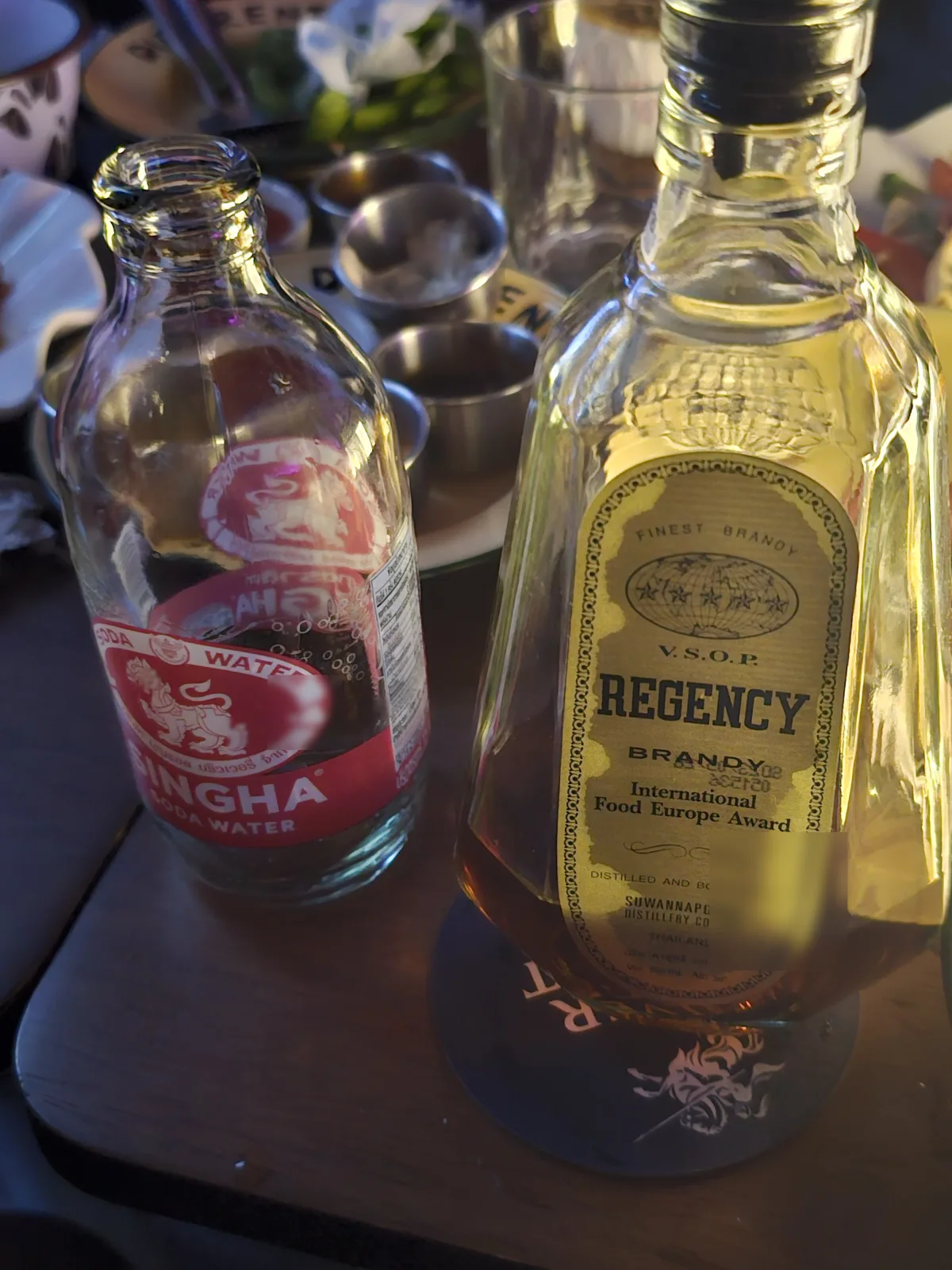 Singha soda and Regency brandy bottles on the table