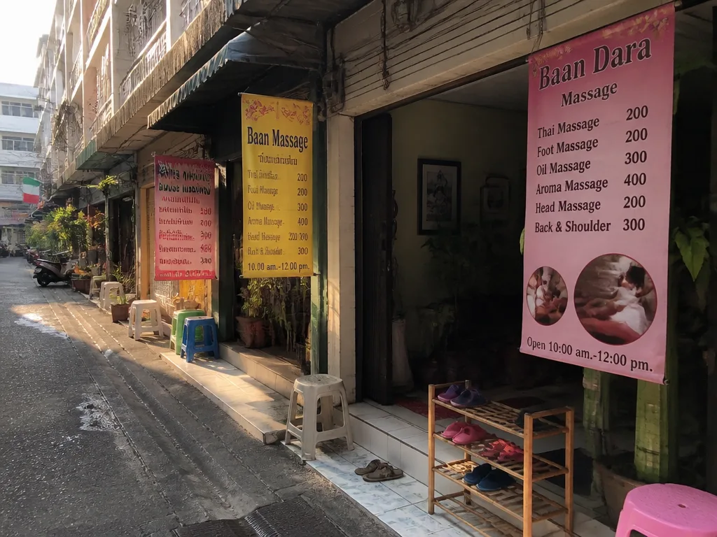 曼谷小巷按摩店挂着粉黄两色价目牌