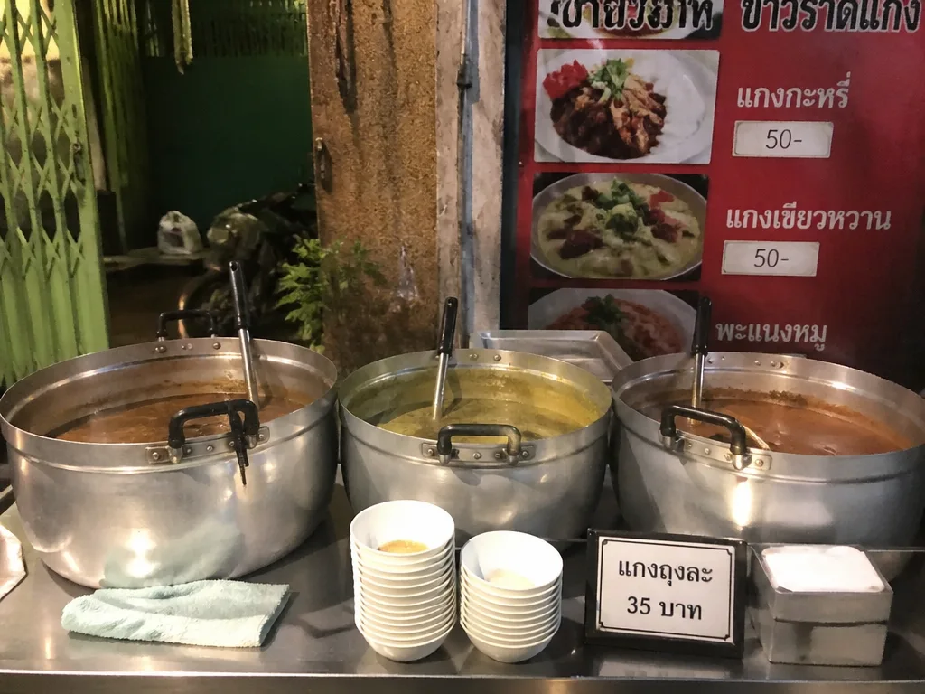 Thai street food vendor counter with steaming pots