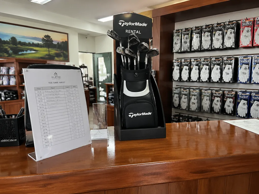 Pro shop counter with rental clubs and tee time booking sheet