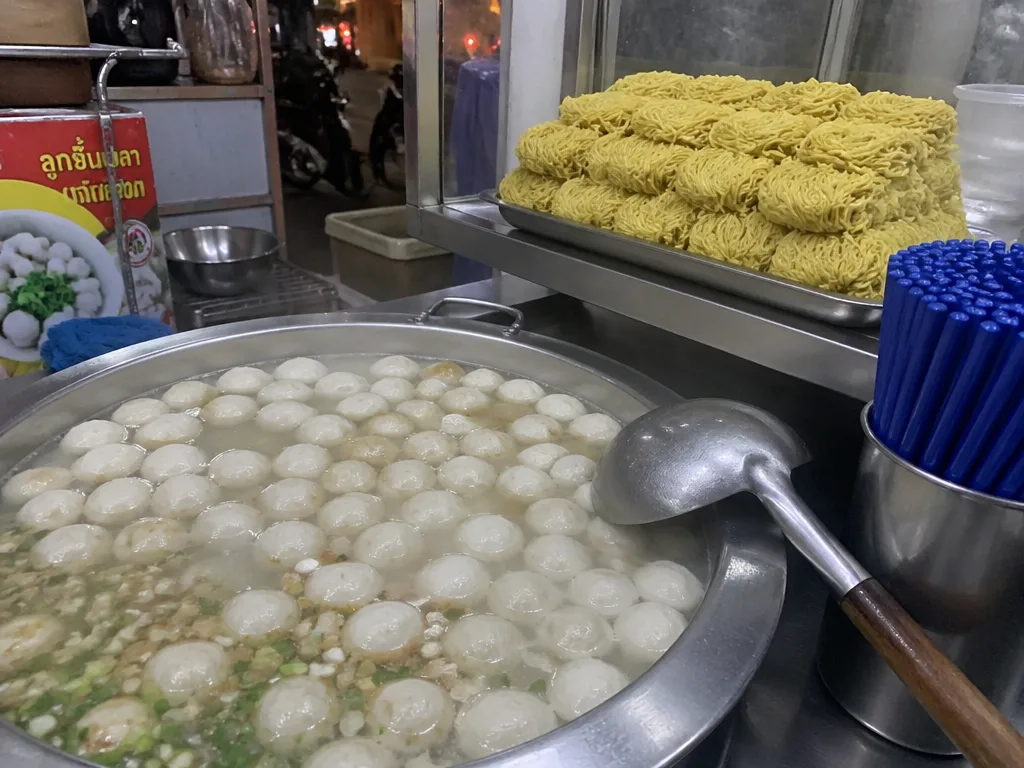 Hand-pulled fishballs simmering in clear broth at noodle stall